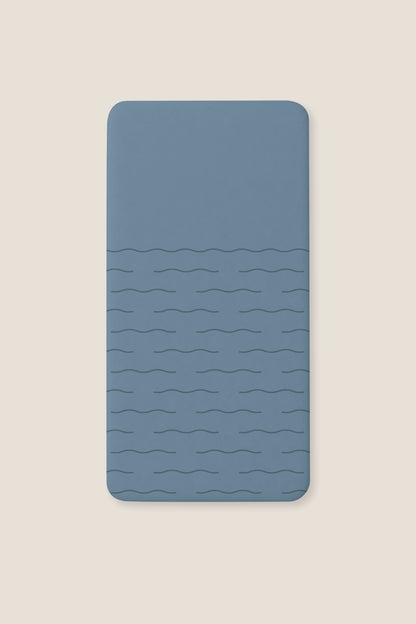 A fitted blue sheet with a subtle wavy horizontal line pattern, shown flat against a light beige background.
