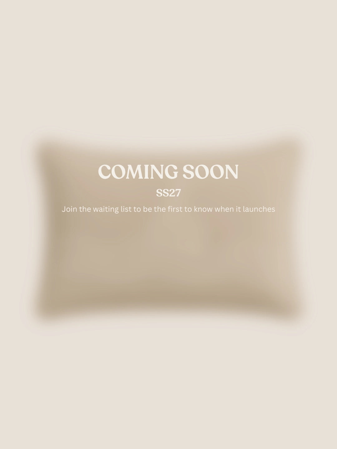 A soft beige rectangular cushion shown on a light warm beige background with centered text reading 'COMING SOON' and smaller text 'SS27 Join the waiting list to be the first to know when it launches.'.