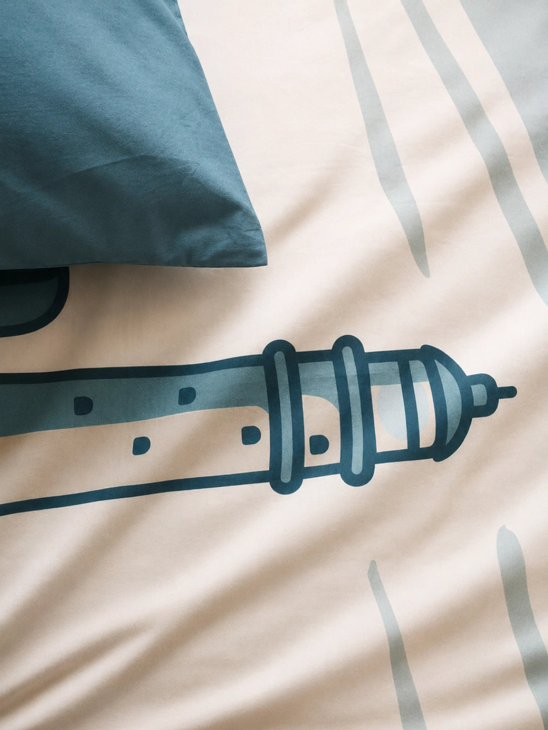A close-up of a duvet cover with the FastNet Rock lighthouse illustration and matching pillowcase.