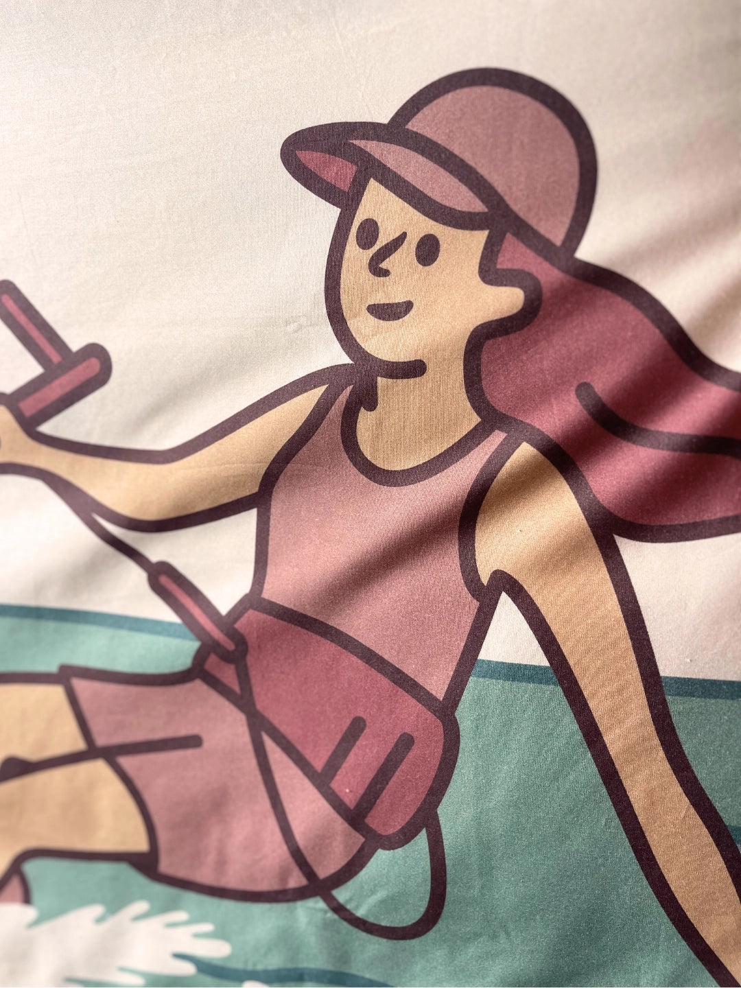 A close-up of a printed illustration on a organic cotton duvet cover, showing a girl Kitesurfing.