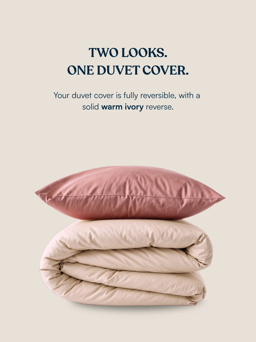 A duvet cover set set shown on a warm beige background with marketing text. The top pillow is dusty rose, and the folded duvet underneath is a warm ivory, illustrating the reversible nature of the product.