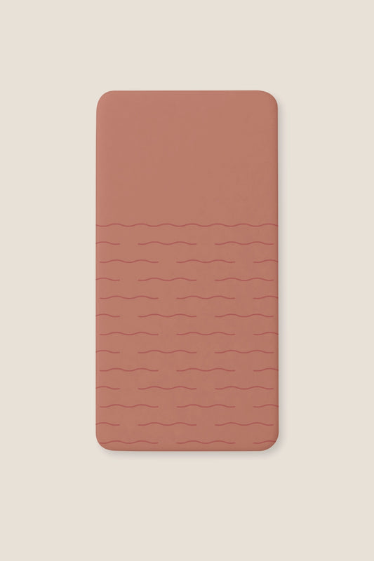 A fitted sheet with a subtle wavy horizontal line pattern, shown flat against a light beige background.