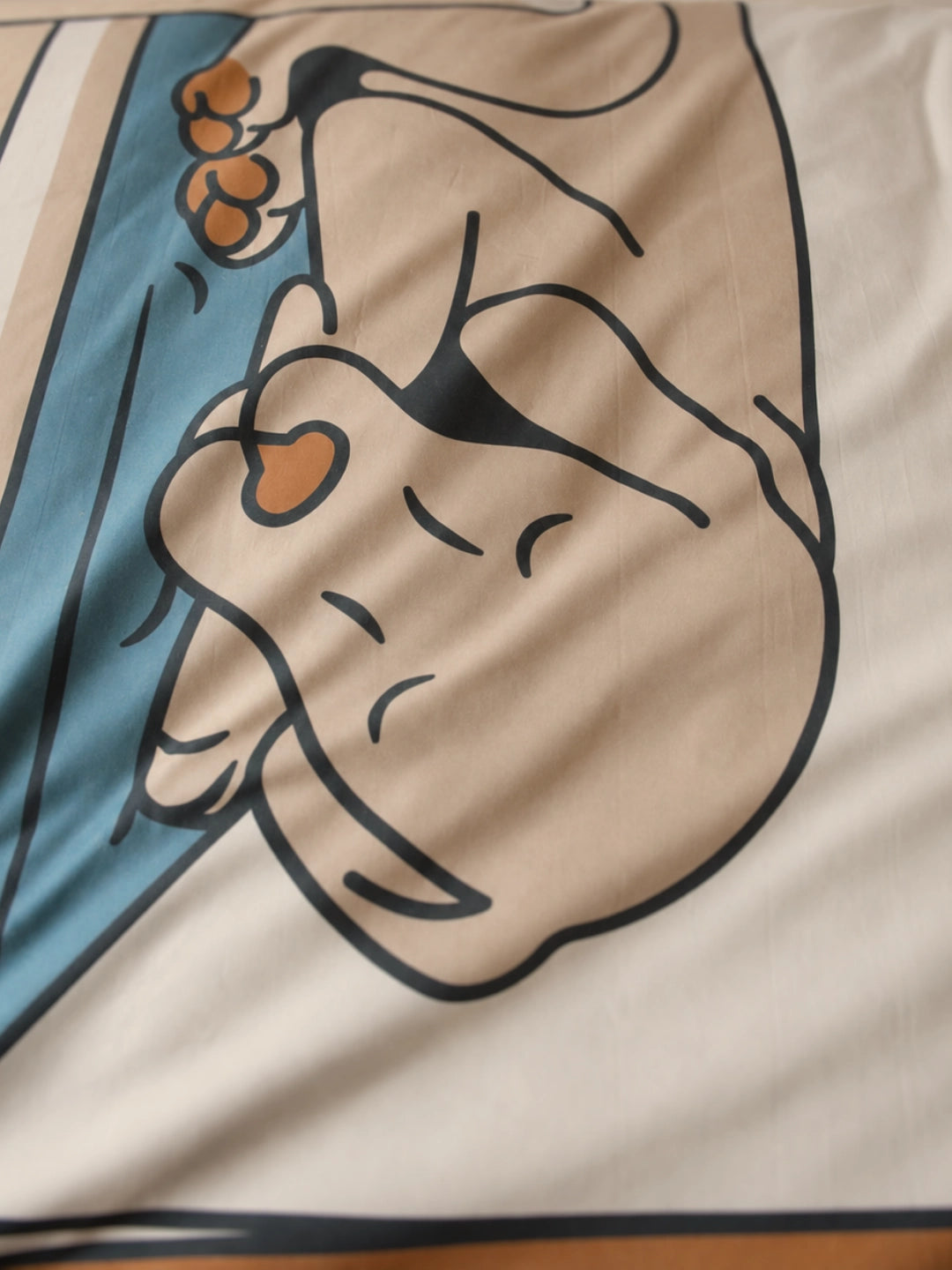 A close-up of a beige sleeping dog illustration on a duvet cover for kids.